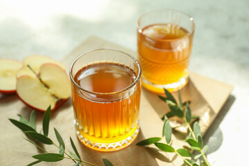 Glasses of apple juice on light background