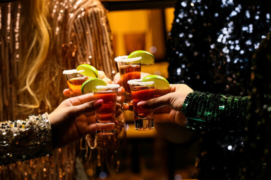 Women with shots of tasty tequila in bar, closeup