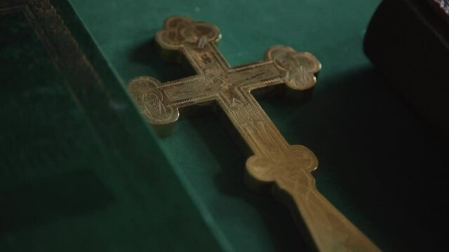 Christening in the church, golden religious utensils: bible, cross, prayer book, missal. Details in the orthodox christian church