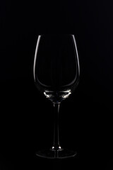 wine glasses and bottles with liquids marking their silhouette with light and black background