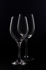 wine glasses and bottles with liquids marking their silhouette with light and black background
