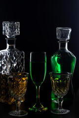 wine glasses and bottles with liquids marking their silhouette with light and black background