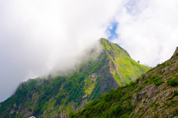 Fototapeta premium Mountain peaks in summer on a sunny day together with clouds