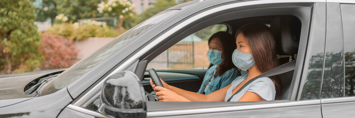 Car driving driver woman wearing face mask with passenger sitting in front. Asian family road trip vacation banner panoramic.