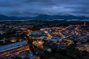 Aerial view of scenic tourist town of Killarney in county Kerry in Ireland with switched on lights under a cloudy early rise morning cloudy sky
