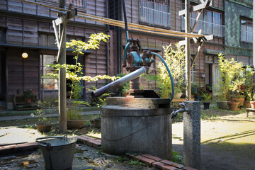 井戸に水汲みポンプがある下町の昔の風景