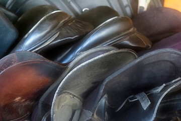 Old saddle, saddler. Horse equipment. Many leather horse saddles