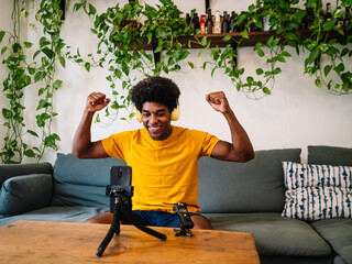 Smiling afro man content creator records a video for social media