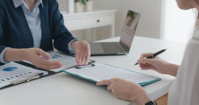 Close-up hand asia people woman fill rent loan form write legal debt letter at lawyer home office. Happy female life buy or sell new house deal from real estate sale agent. Tax advice talk and smile.