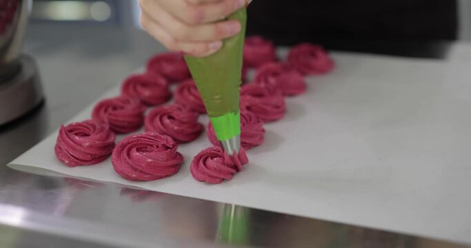 Squeeze violet marshmallow cream mass from the pastry bag