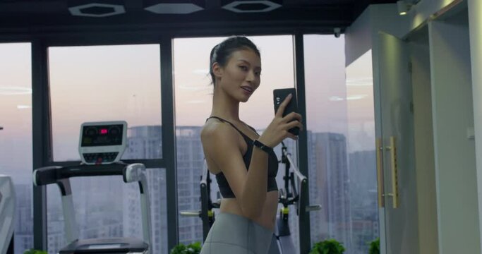 Young woman taking selfie with smartphone at gym,4K