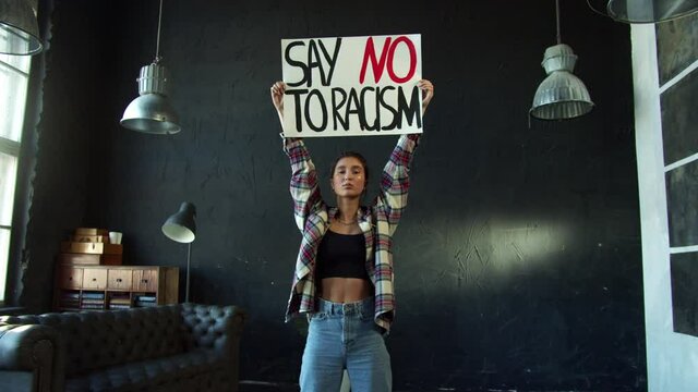 Young outraged holding protest banner demanding stop racial discrimination