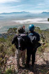 A group of young travelers are walking along a trail in the mountains