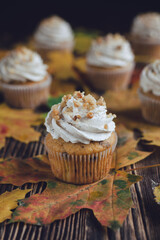 Autumn fall spicy cupcakes with walnuts, on the wooden rustic background, decorated with fall leaves.	
