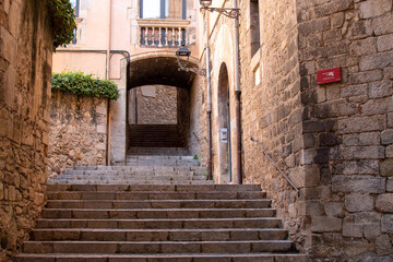 Fototapeta na wymiar Empty alley with stone stairs in the old town, Girona