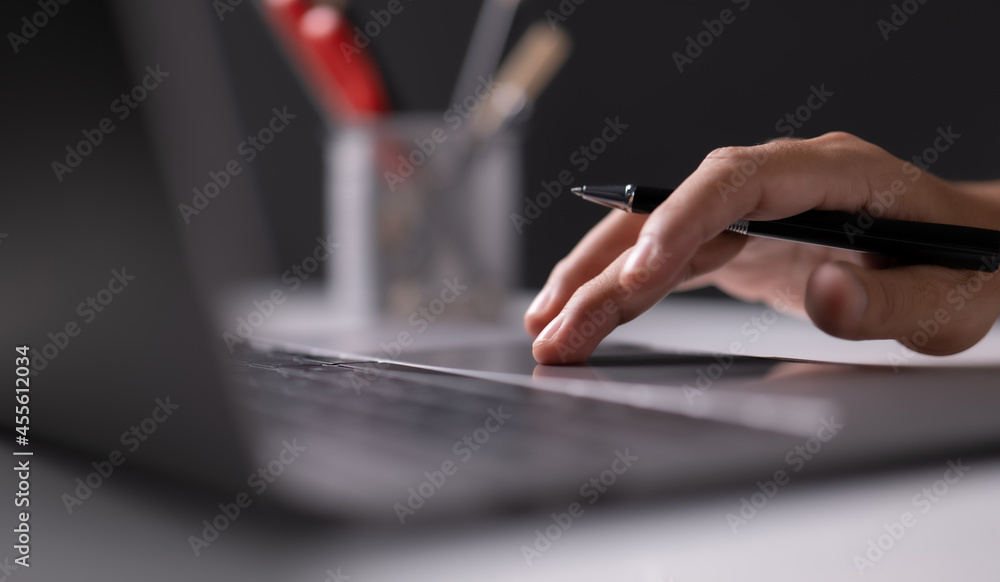 Poster Man using laptop computer working on new project idea at desk in the office late at night with copy space