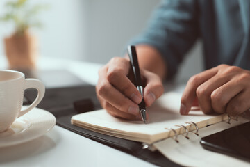 home office desk background, Hand holding pen and writing note on table, Checklist Notice Remember...