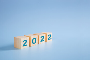 2022 number on wooden block on blue background