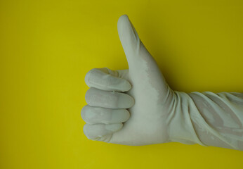 hand wearing latex gloves isolated in yellow background