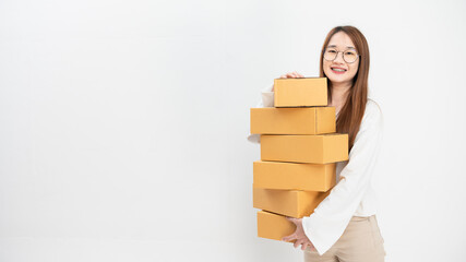A young asian female entrepreneur holds several boxes in her hands.Mailing of products in the online store. Delivery of goods to customer. Sale products online concept.