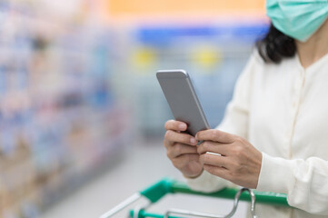 Asian woman wearing medical face mask in supermarket for prevent  dust the spread of germs and...