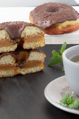 Pile of donuts with dulce de leche and cup of tea.