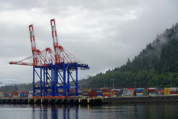 Container cranes loading shipping containers at the port in Prince Rupert, British Columbia, Canada.