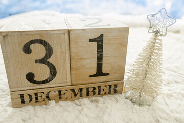 Wooden calendar showing New Year eve date 31 December on winter background