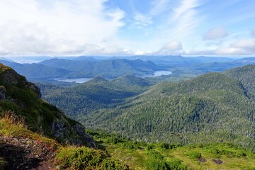 Fototapeta na wymiar A beautiful view of the scenic ocean and forested mountains from on the top of mount raymond, on the sleeping beauty trail in Haida Gwaii, British Columbia, Canada