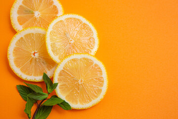 sliced lemons on orange background