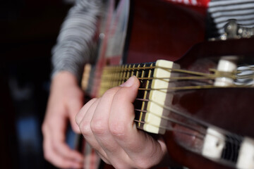 Fototapeta premium The hands of a young girl play the guitar