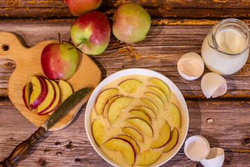 Homemade apple pie. There are apples, milk and apple pie on a wooden background.