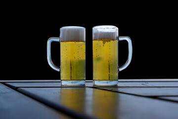 beer for two on wooden table black background