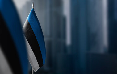 Small flags of Estonia on a blurry background of the city