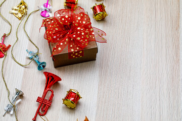 Small gift present box with colorful ribbon bow tie placed on wooden table with small decorative...