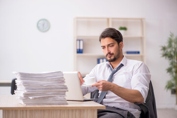 Fototapeta premium Young male employee drinking coffee during break