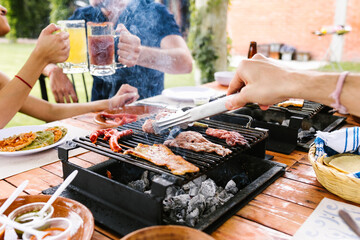 latin people eating Mexican food, Tacos, spicy salsa, tortillas, beer, snacks and peoples hands over wood table in a restaurant terrace in Mexico Latin America