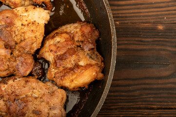 Fried pieces of meat in a frying pan, close-up, selective focus.