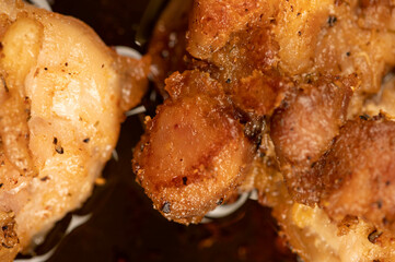 Fried pieces of meat in a frying pan, close-up, selective focus.