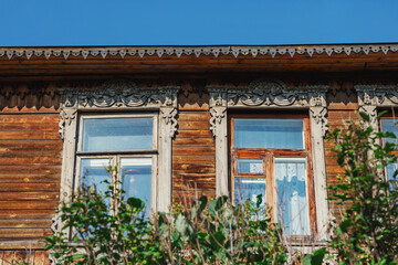 Fototapeta na wymiar A beautiful building from the beginning of the 19th century, decorated with carved wood. Living conditions in the old town. Country house on a summer day.