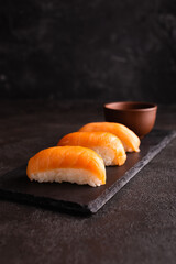 Philadelphia sushi on a black plate