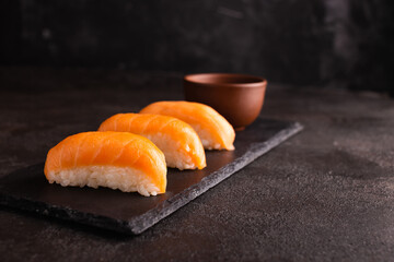 Philadelphia sushi on a black plate