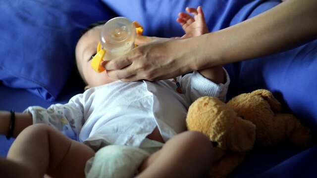 Active baby drink the milk and exercise the hand and leg