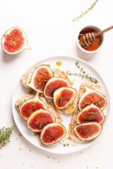 Fototapeta na wymiar Breakfast with sweet bruschettas with figs and honey on a white plate