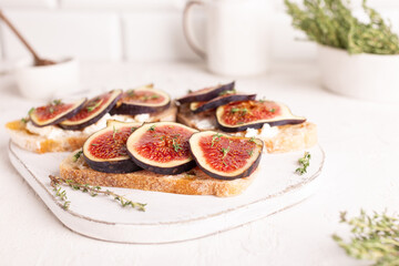 Breakfast with sweet bruschettas with figs and honey on a white plate