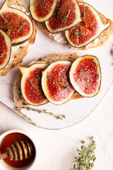 Breakfast with sweet bruschettas with figs and honey on a white plate