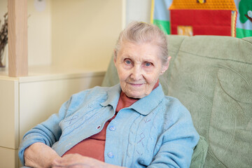 Portrait of a grandmother, an old woman sitting at home, 90 years old, old age, wrinkles on her...