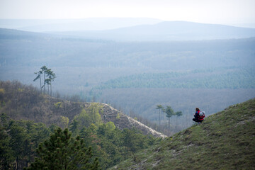 Hilly landscape with person squatting on a slope