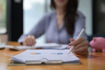 Close up view businesswoman holding pen and pointing on financial document.