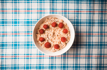 Oatmeal porridge with sweet raspberries. Selective focus.